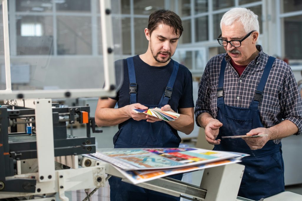 Two PDF print workers looking at a color fan